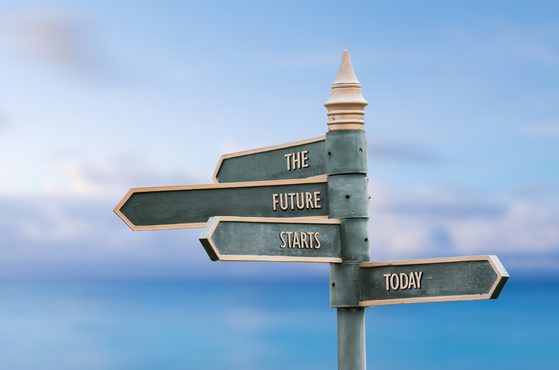 A signpost with four arrows pointing in different directions against a beach background, reading "The Future Starts Today."