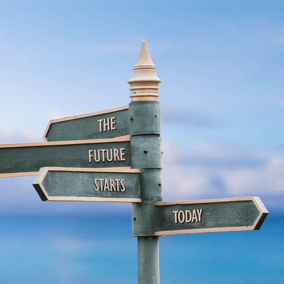 A signpost with four arrows pointing in different directions against a beach background, reading "The Future Starts Today."