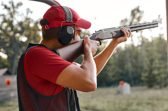 A man holds a gun and a shooting range