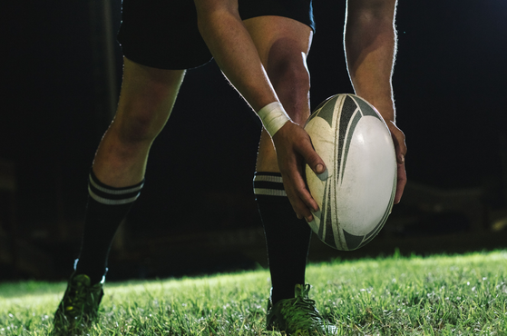 A rugby player prepares to a kick a rugby ball