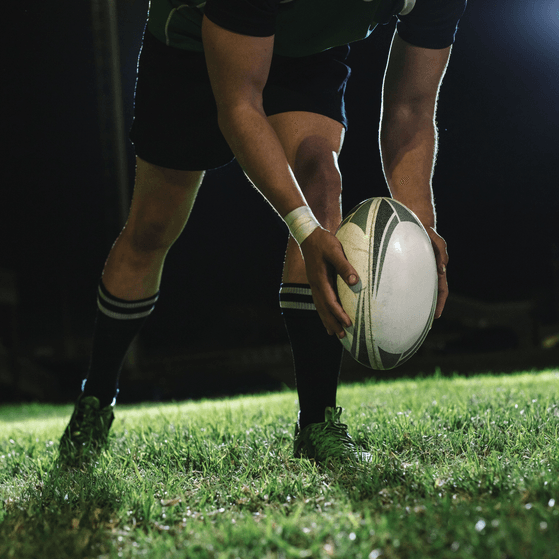 A rugby player prepares to a kick a rugby ball