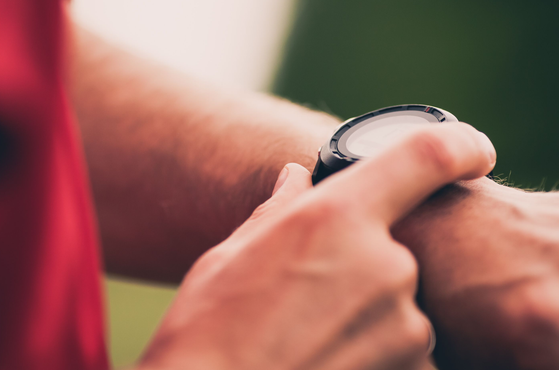 A runner checks their smart watch
