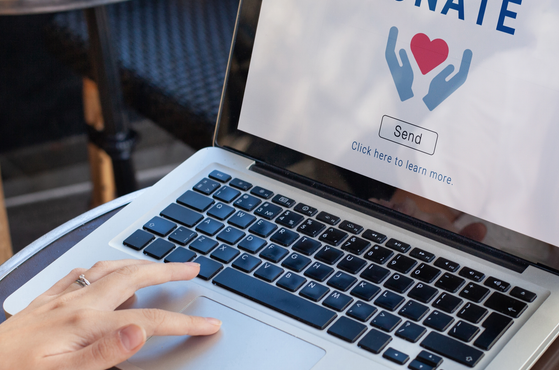 A charitable donation is made online on a laptop
