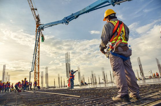 Construction workers building crane