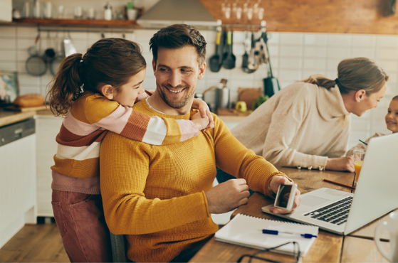 Warm kitchen scene with a person in a mustard sweater smiling at a laptop, a child hugging from behind, while another person and a child chat at the far end.