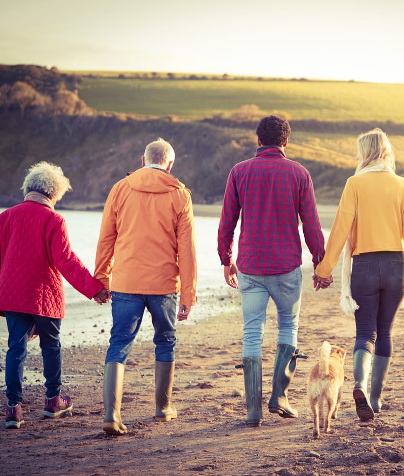 Adult couple and parents walking on beach