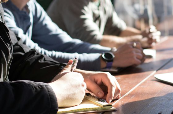 Directors sit at a table and discuss setting up a competitor business