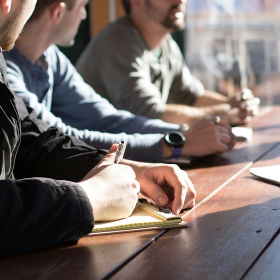 Directors sit at a table and discuss setting up a competitor business
