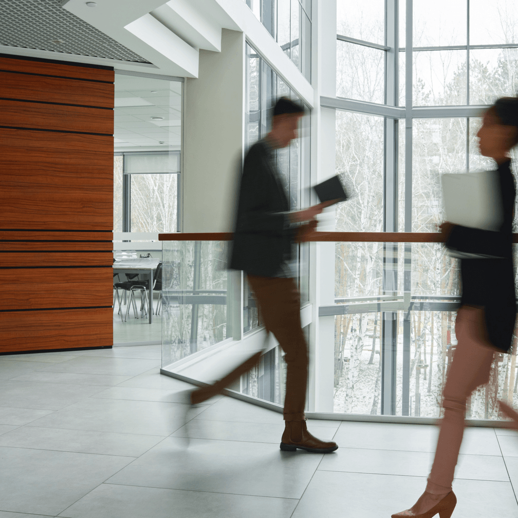 Colleagues walk past each other in an office