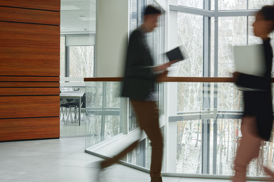 Colleagues walk past each other in an office