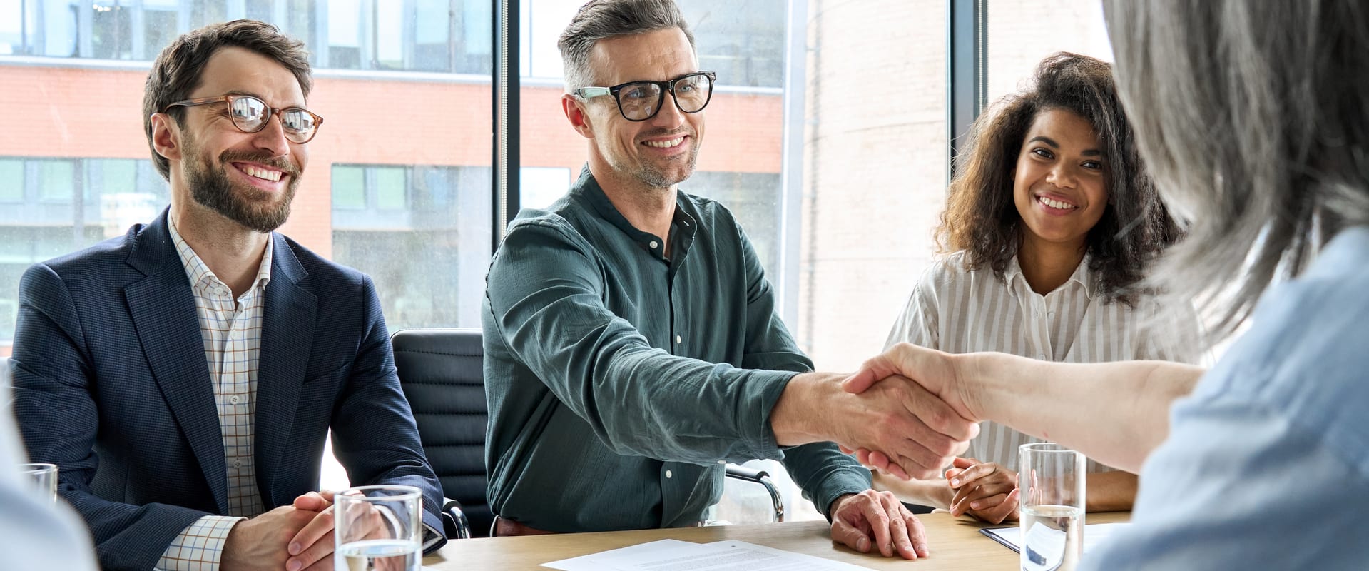 Stakeholders shake hands in a business meeting