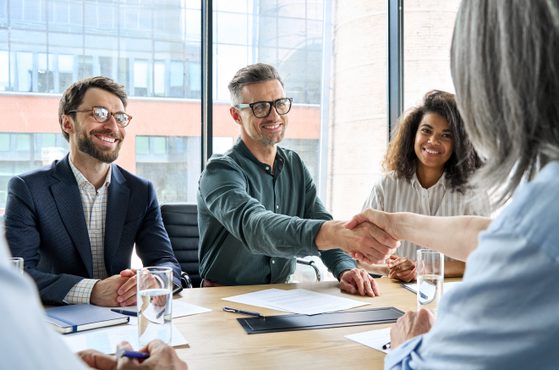 Stakeholders shake hands in a business meeting