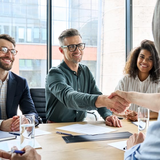 Stakeholders shake hands in a business meeting